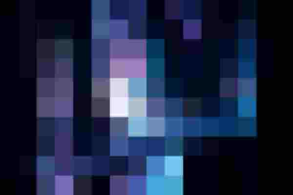 Schauspielerin in weißem Hemd hinter dunklen Stoffbahnen auf einer Bühne