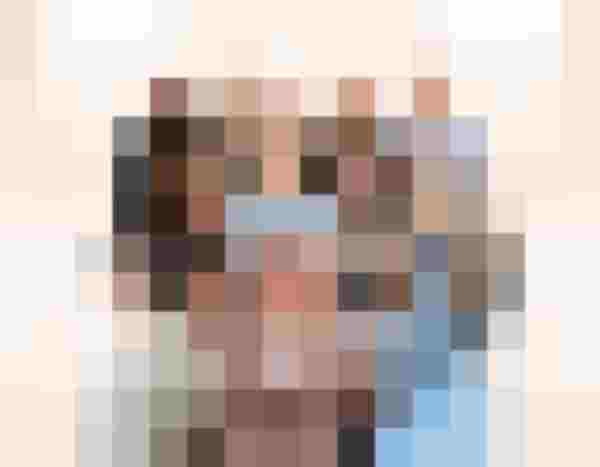 Gruppenporträt von elf lächelnden Frauen in drei Reihen vor hellem Hintergrund